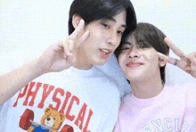 two young men are posing for a picture and one of them is wearing a physical t-shirt .
