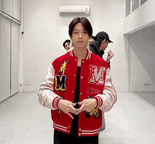 a man wearing a red jacket with the letter m on the front