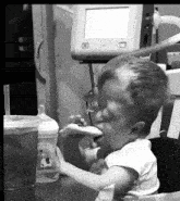 a black and white photo of a toddler eating a piece of food