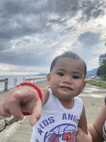 a baby wearing a los angeles shirt is being held by a woman