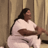 a woman in a white shirt and white pants is dancing