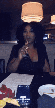 a woman sitting at a table with a glass of wine