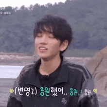 a young man in a black jacket is making a funny face with his eyes closed