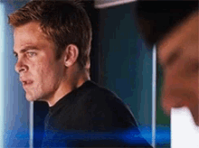 a man in a black shirt is standing next to another man .