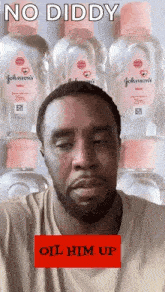 a man with a beard is standing in front of a stack of baby oil bottles .
