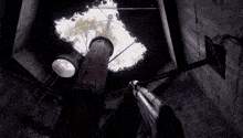 a person is holding a gun in a dark room and looking up at a tree .
