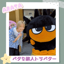 a picture of a person standing next to a stuffed animal with the name arata on the top