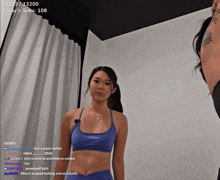 a woman in a blue sports bra stands in front of a white curtain while a streamer talks to her