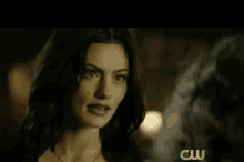 a close up of a woman 's face with a cw logo on the bottom right