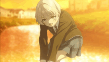 a girl in a school uniform is kneeling down in a field