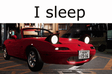 a red car with a license plate that says 15-16 is parked in a parking lot