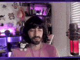 a man with a beard wearing headphones and a stuffed monkey on his shoulder .