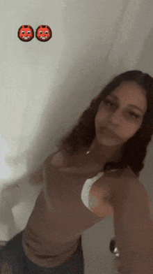 a woman taking a selfie in front of a white wall with two red faces on it