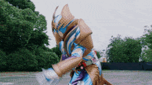 a man in a blue and gold costume is standing in a parking lot