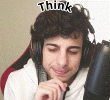 a man wearing headphones is sitting in front of a microphone .