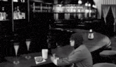 a man sits at a bar with a pizza on a napkin