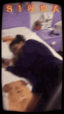 a blurry picture of a person laying on a bed with simba written on the bottom right