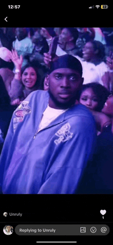 a man in a purple jacket is standing in front of a crowd of people