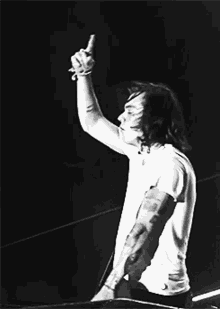 a black and white photo of a man with tattoos on his arm