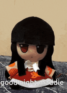 a stuffed doll is sitting on a blanket and says good night maddie