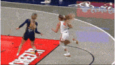 two female basketball players are playing on a court with a cheetos advertisement on the floor