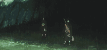 a couple of people standing next to each other in the dark holding guns .