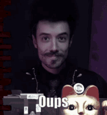 a man covering his mouth with his hands next to a statue of a cat with the word oops on it