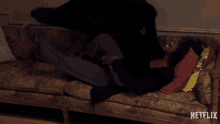 a man is laying on a couch with a netflix logo in the corner