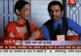 a man and a woman are on a television screen with a headline in a foreign language