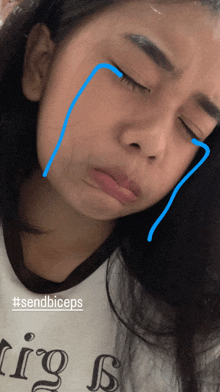 a girl wearing a shirt that says " sendbiceps " crying