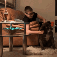 a boy petting a dog while sitting in a chair
