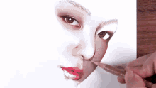 a person is drawing a close up of a woman 's face with a pencil .