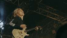 a man playing a guitar with a shirt that says visa on the sleeve