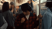 a man wearing headphones is riding a subway with the hashtag #karatekidmovie