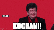 a woman in a black suit and red scarf says kochani !