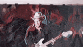 a man wearing a cowboy hat is playing an electric guitar