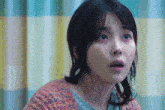 a close up of a woman 's face with a shocked look on her face