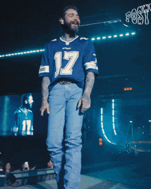 a man wearing a blue shirt with the number 17 on it is singing into a microphone