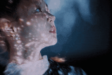 a close up of a woman 's face with a reflection of stars on it