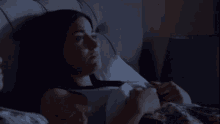 a woman is laying in a bed with her eyes closed