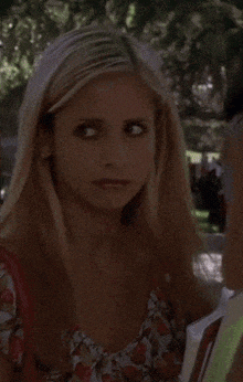 a woman with blonde hair is holding a magazine and looking at the camera