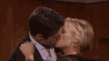 a man and a woman are kissing each other in a room .