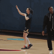 a female basketball player is giving a high five while walking on the court