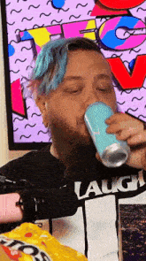 a man with blue hair and a beard drinking from a blue can