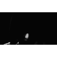 a black and white photo of a woman in a white dress with a red ribbon