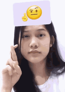 a girl is holding a card with an emoji face on it
