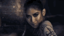 a woman is making a face with her hands in a dark room .