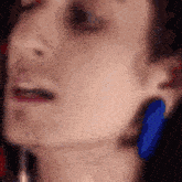 a close up of a woman 's face with a blue object in the foreground .