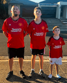 a man and two boys wearing team viewer jerseys