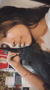 a woman laying on a bed with a coca cola sign in the background